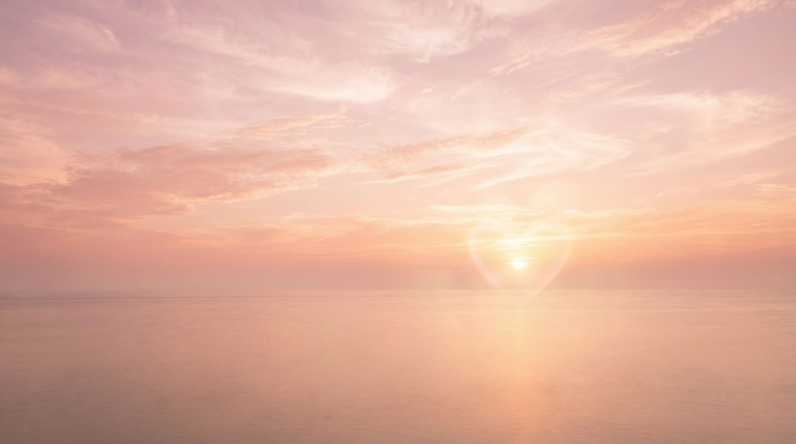 coucher de soleil rose sur l’océan avec flare en cœur